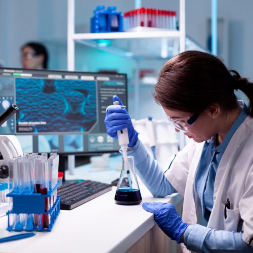 Chemistry doctor in engineering virus with mciropiette medicine dropper. Woman research a new experiment in modern lab, analyzing pharmaceutical work with modern equipment.