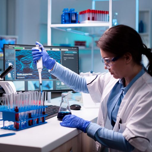 Medical engineer scientist uses micropipette, pipette taking sample from test tube. Woman research a new experiment in modern lab, analyzing pharmaceutical work with modern equipment.